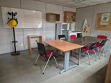 a room with a table, chairs, and a refrigerator in it