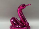 pink balloon shaped like a bird sitting on top of a white surface