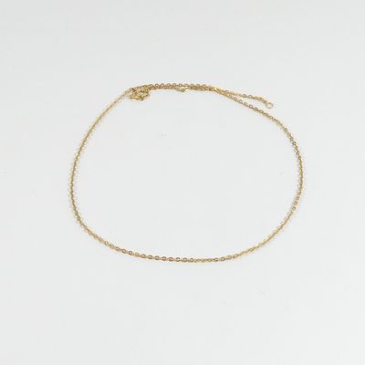 un bracelet de cheville en chaîne d'or orné d'un petit pendentif en forme de cœur