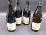four bottles of wine are lined up on a table