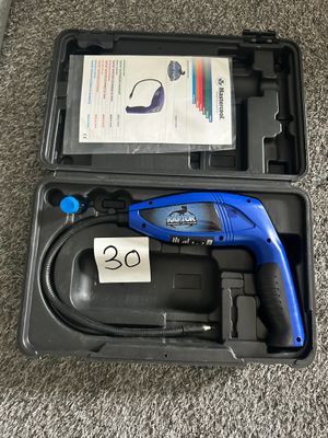 un outil bleu et noir dans un étui posé par terre