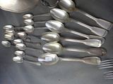 a lot of silver spoons and forks on the table