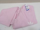 pink sweat pants with white logo on the bottom and a blue tag on the bottom of the pants