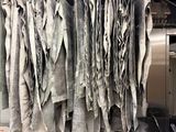 a lot of dirty clothes hanging from the ceiling