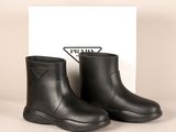 a pair of black rain boots with a prada logo on the side