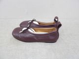 pair of purple leather shoes with metal buckles on a white surface