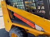the front end of a yellow ski - loader parked on the side of the road