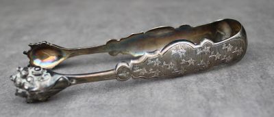 une cuillère en argent ornée d'une fleur, posée sur une table