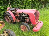 un tracteur rose qui est garé dans l'herbe