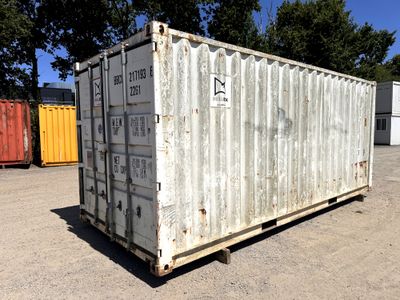 a white container sitting on a pallet in a parking lot