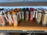 many cans of paint sitting on a shelf in a room