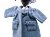 un mannequin vêtu d'un manteau bleu et d'un chapeau