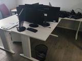 un bureau sur lequel sont posés deux écrans et un ordinateur portable