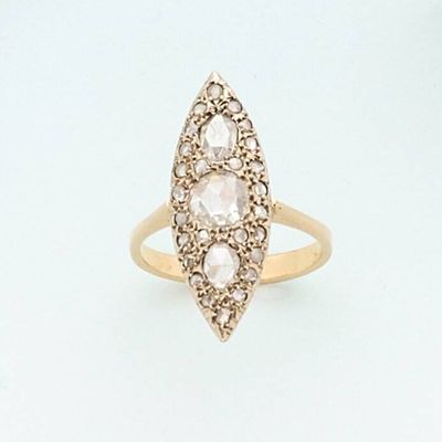 a close up of a gold ring with three diamonds on it