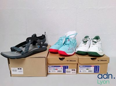 three pairs of shoes sitting on top of boxes in front of a white wall