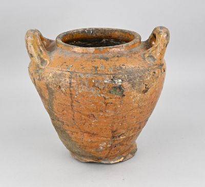 un vase brun posé sur une surface blanche