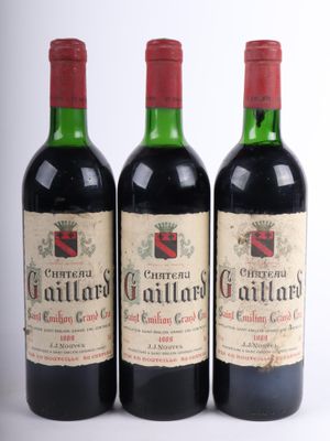 trois bouteilles de vin rouge posées l'une à côté de l'autre sur une surface blanche
