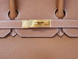a close up of a brown leather handbag with a gold lock