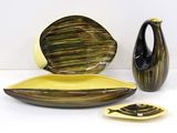 three pieces of pottery sitting on a white surface
