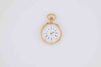 a close up of a gold pocket watch on a white surface