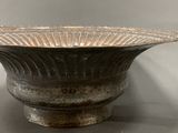 a large metal bowl that is sitting on a table
