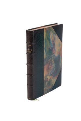 un vieux livre à la couverture noire, ornée d'une peinture