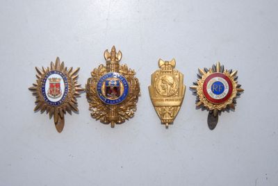 quatre insignes de formes et de couleurs différentes sur un fond blanc