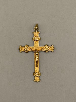 un gros plan d'une croix en or surmontée d'une couronne