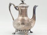 une théière ancienne en argent ornée d'un oiseau sur le couvercle