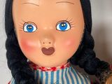 a close up of a doll with long hair and blue eyes
