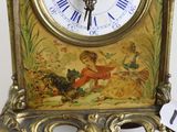 a gold clock with a picture of a woman on it
