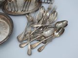 a lot of silver spoons and forks on the table