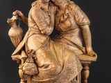 une photo représentant une statue de deux femmes assises sur un banc