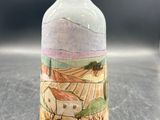 un petit vase avec un tableau posé sur une table