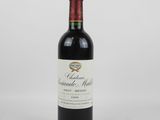 une bouteille de vin rouge posée sur une table blanche
