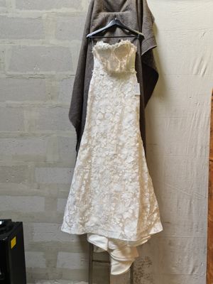 a wedding dress hanging on a hanger in a room