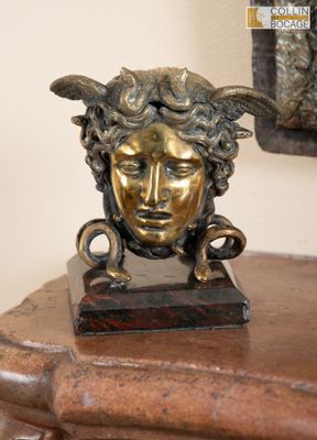 une statue représentant une femme à tête de chèvre posée sur une table