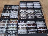 many pairs of glasses sitting in a box on the floor