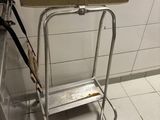 tiled floor in a public restroom with a metal step stool