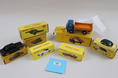 Plusieurs petites voitures et camions sont posés sur une surface blanche.