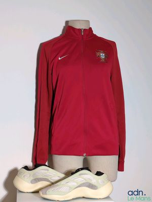 La veste et les chaussures Nike sont présentées sur un mannequin.