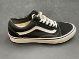 vans old skooler black and white sneakers on a gray surface