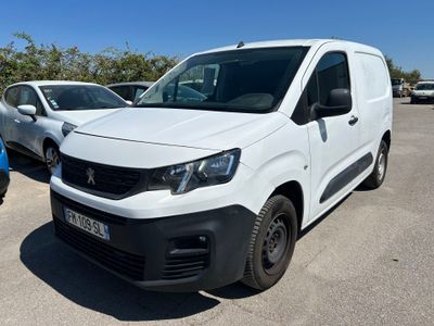 une camionnette blanche garée dans un parking à côté d'autres voitures