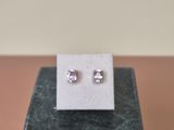 a close up of a pair of earrings on top of a marble block