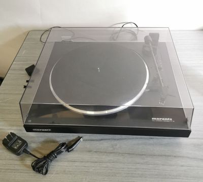 une platine posée sur une table, sur laquelle se trouve un chargeur