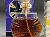 an image of a bottle of perfume next to a box of perfume