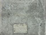 an old book sitting on top of a table next to a piece of paper