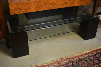 un banc en bois avec un plateau en verre et un tapis posé au sol