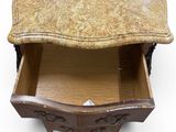 a marble top chest of drawers with a drawer underneath it