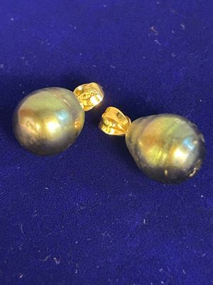 pair of gold tone pearl earrings on a blue background